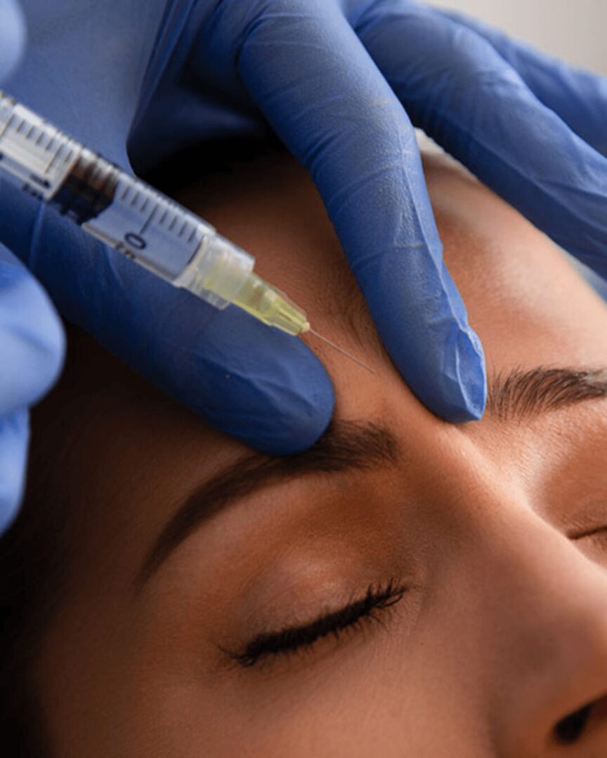 Gloved hands administering forehead cosmetic injection